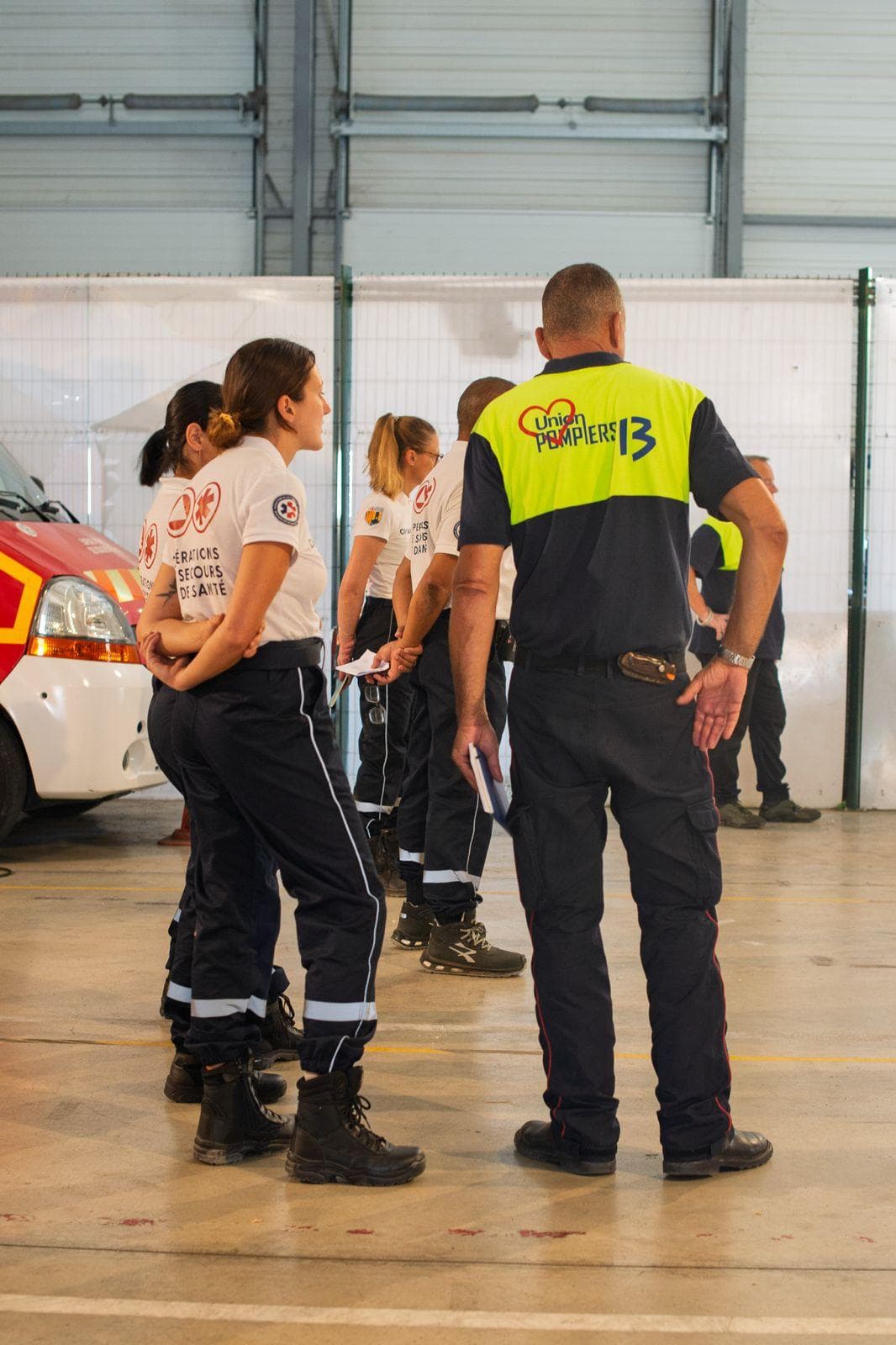Secouristes OPSAN alignés pour la revue des équipes devant un cadre de l'Union des Pompiers 13, en centre de formation